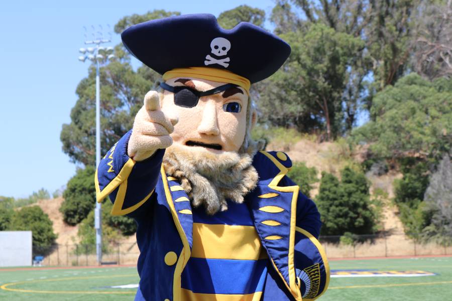 Golden Beard mascot, a pirate look-a-like, pointing at the camera 